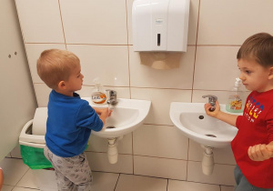 Tymuś i Piotruś ćwiczą prawidłowe mycie rąk.